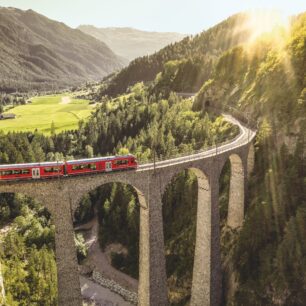 Červený vlaček Rhérské dráhy na viaduktu Landwasser. Zdroj: Switzerland Tourism / Rob Lewis