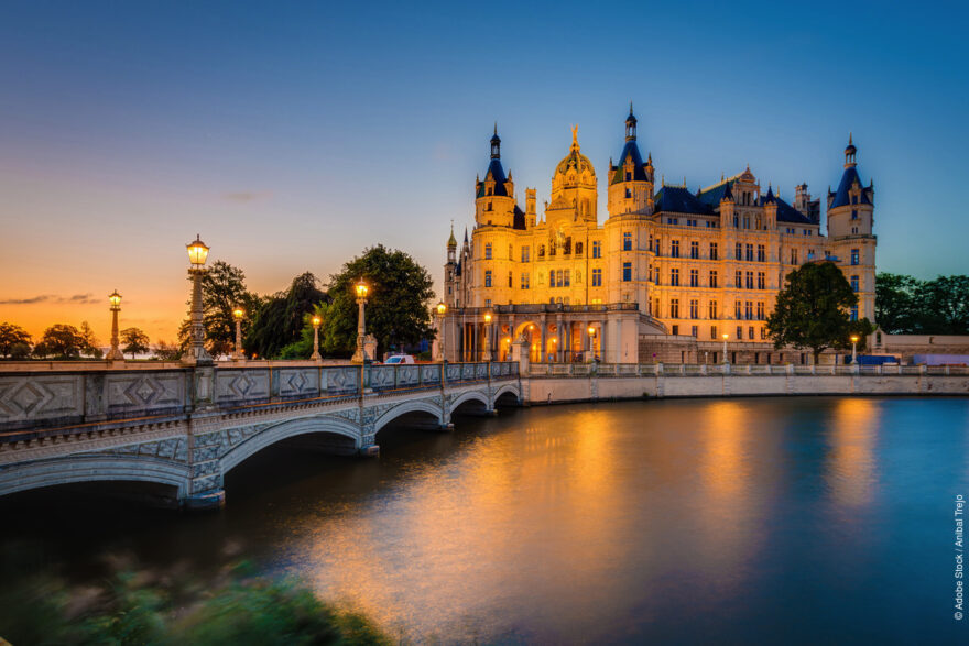 Schwerin: Zámek při západu slunce na jezeře Schweriner See © Adobe Stock/Anibal Trejo