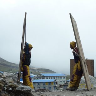 Nosiči odpočívají při transportu materiálu do oblasti, zasažené zemětřesením, Langtang, Nepál