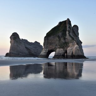 Wharariki beach, známá z filmu Hobit, je přistupná, jak jinak, než zdarma. Nový Zéland