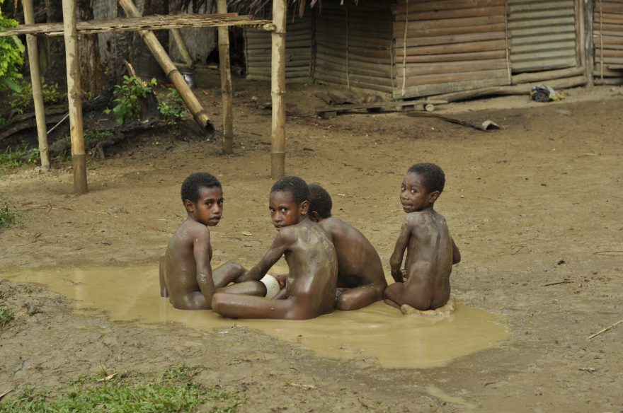 Děti mají radost z maličkostí - třeba z koupání v louži, Papua Nová Guinea